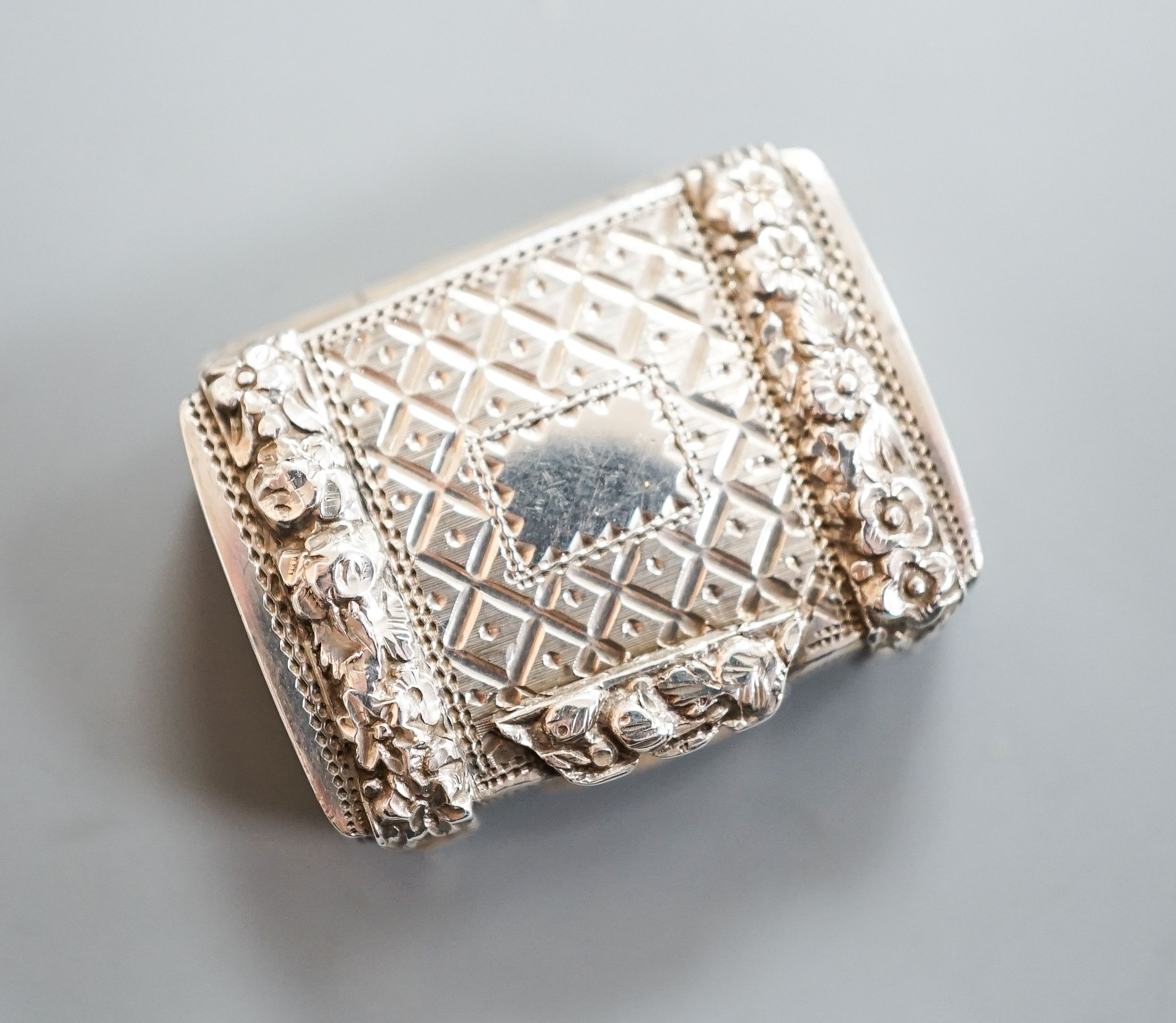 A George IV silver vinaigrette, by John Bettridge, with embossed flower head decoration, Birmingham, 1820, 26mm.